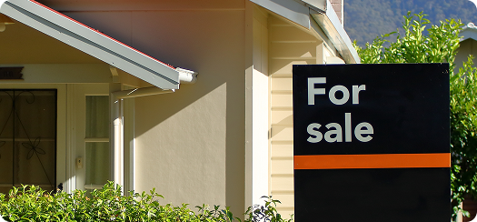 a for sale sign in front of a home